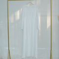 Gold clothing rack with a white shirt on a white background