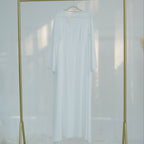 Gold clothing rack with a white shirt on a white background